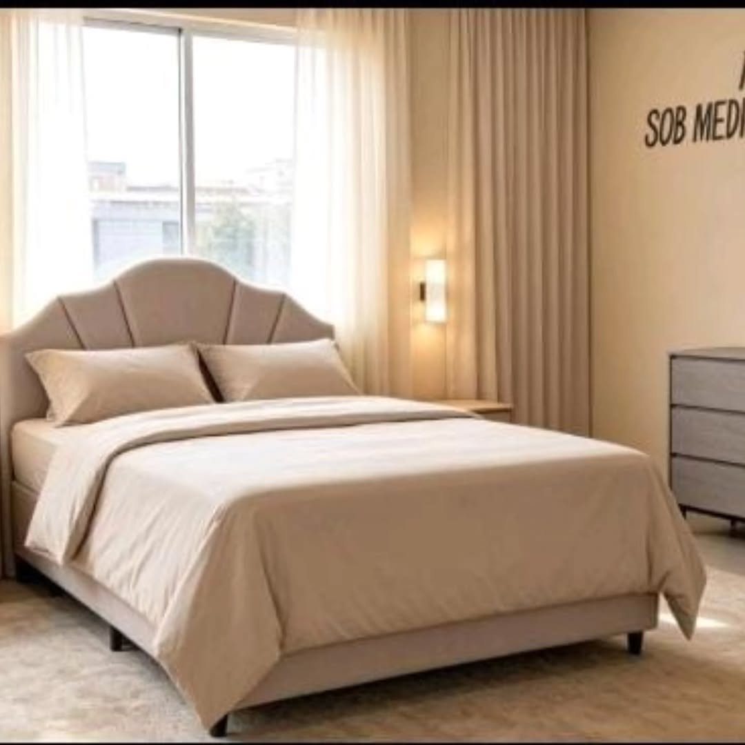 Quarto com cama estofada bege e cabeceira arredondada