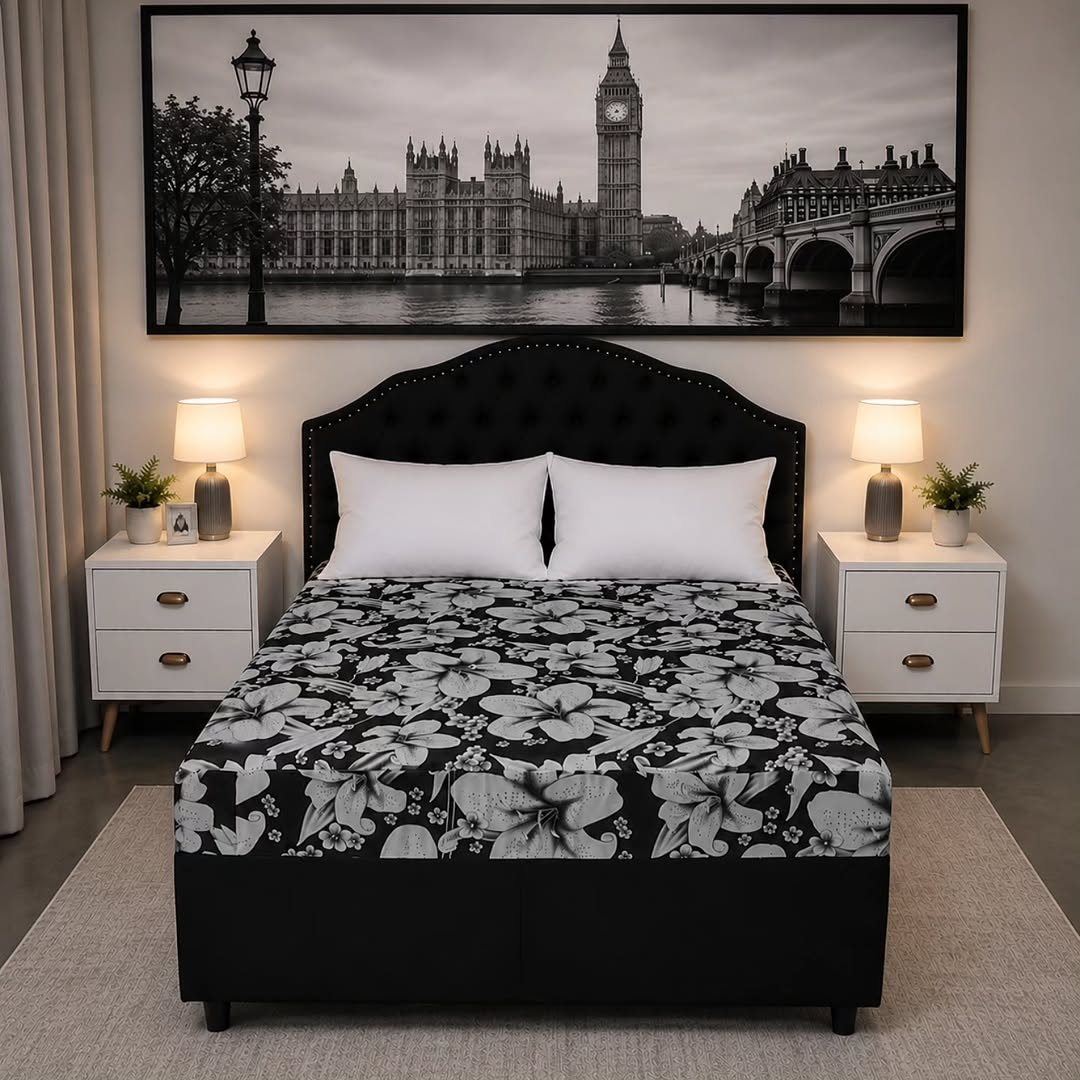 Cama com estofado floral preto e branco e cabeceira preta capitonê